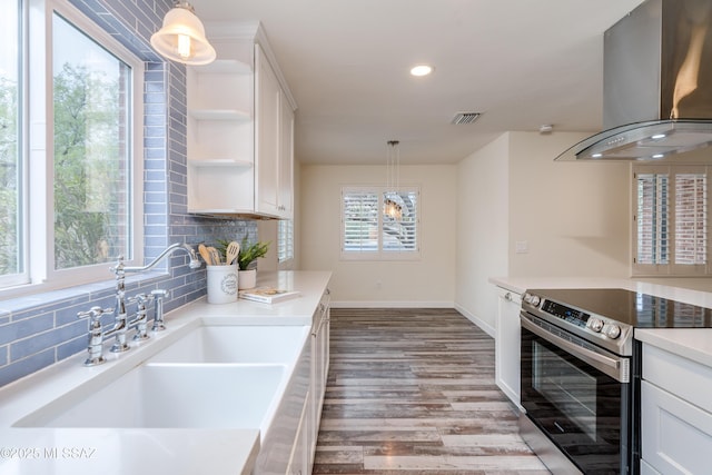 38 N Irving Ave, Tucson, AZ 85711 - kitchen with wall chimney range hood, electric stove, a sink, baseboards, and visible vents