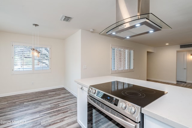 38 N Irving Ave, Tucson, AZ 85711 - kitchen with island exhaust hood, stainless steel electric range, visible vents, and light wood-style flooring