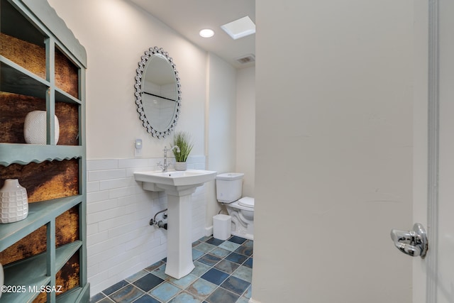 38 N Irving Ave, Tucson, AZ 85711 - bathroom featuring tile patterned floors, toilet, tile walls, wainscoting, and visible vents