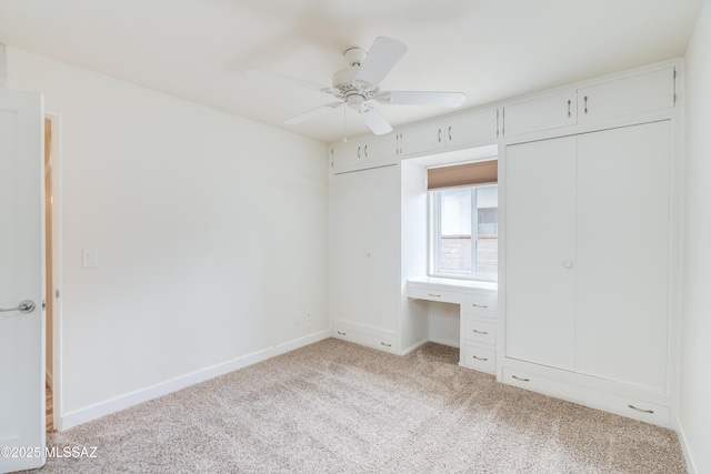 38 N Irving Ave, Tucson, AZ 85711 - unfurnished bedroom featuring built in study area, ceiling fan, baseboards, and light carpet