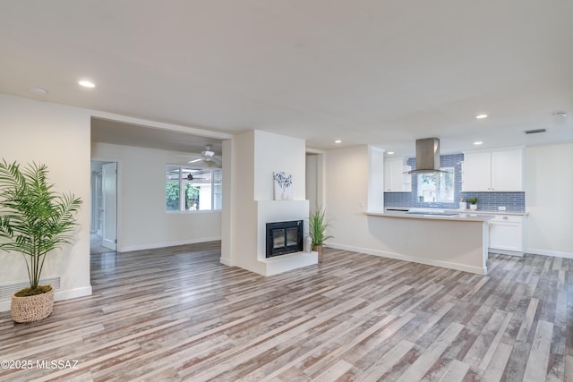 38 N Irving Ave, Tucson, AZ 85711 - unfurnished living room featuring recessed lighting, light wood-style floors, and a multi sided fireplace