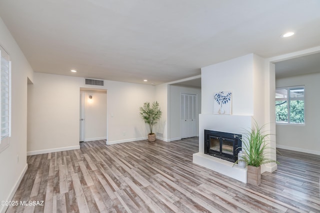 38 N Irving Ave, Tucson, AZ 85711 - unfurnished living room with a glass covered fireplace, wood finished floors, visible vents, and recessed lighting