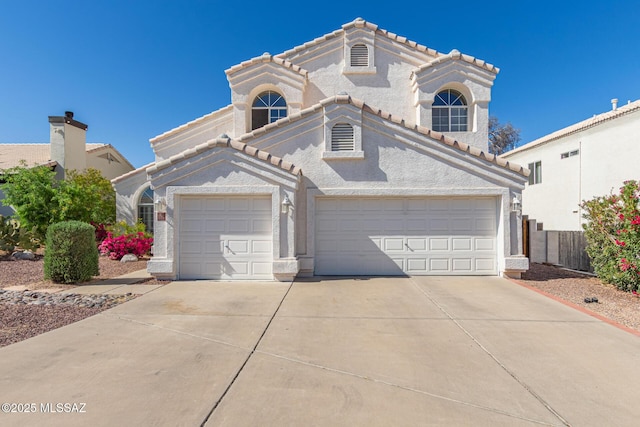 mediterranean / spanish house featuring fence, concrete driveway, a tile roof, an attached garage, and stucco siding
