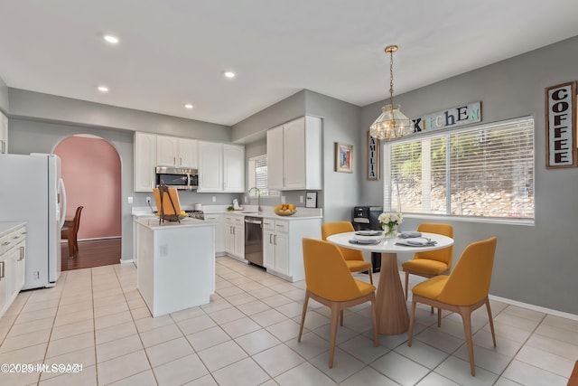 3762 W Meadow Briar Dr, Tucson, AZ 85741 - kitchen with appliances with stainless steel finishes, a sink, arched walkways, light countertops, and white cabinetry
