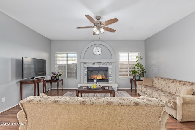 living room with wood finished floors, a ceiling fan, a fireplace, and plenty of natural light