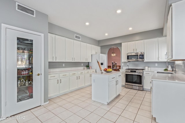 kitchen featuring white cabinets, a sink, visible vents, stainless steel appliances, and light countertops