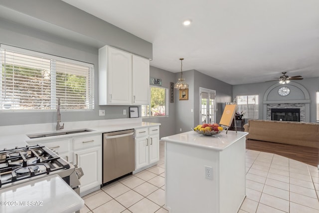kitchen featuring light tile patterned floors, a center island, a sink, and stainless steel appliances