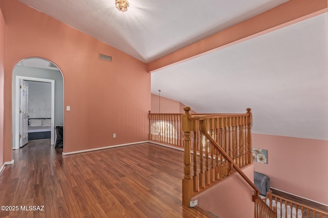bonus room with lofted ceiling, wood finished floors, visible vents, and baseboards