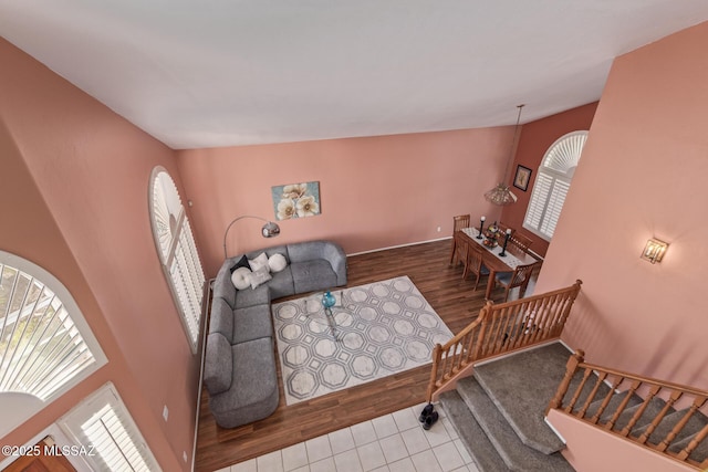 sitting room featuring stairs, vaulted ceiling, and wood finished floors