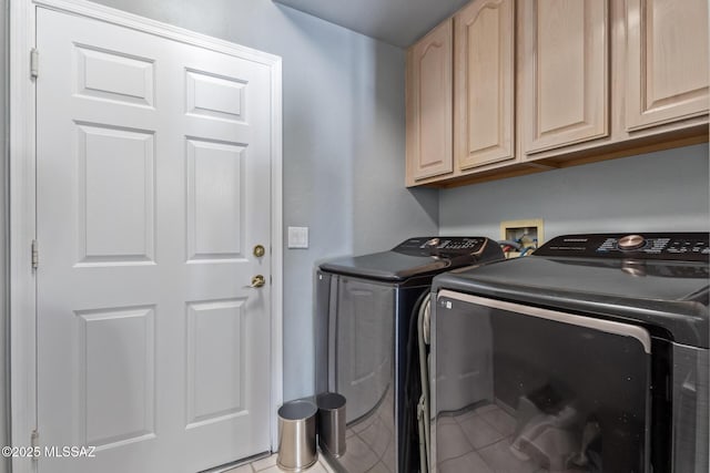 laundry room featuring tile patterned flooring, washer and dryer, and cabinet space