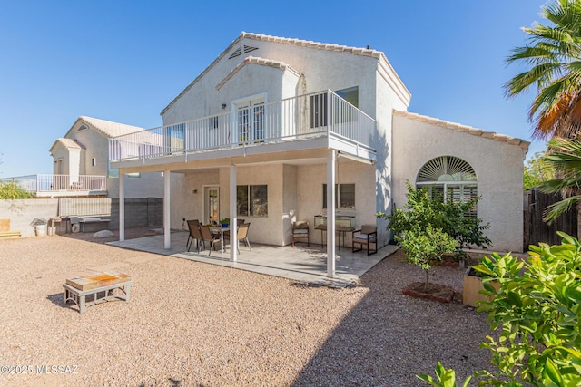 back of property featuring a patio, fence, stucco siding, and a balcony