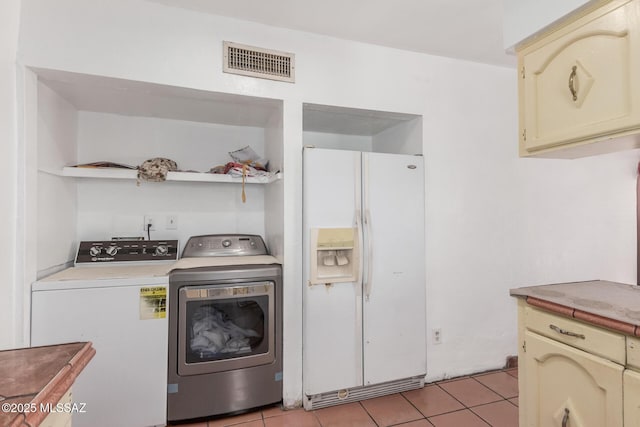 414 E 34th St, Tucson, AZ 85713 - laundry area with light tile patterned floors, visible vents, laundry area, and washer and clothes dryer