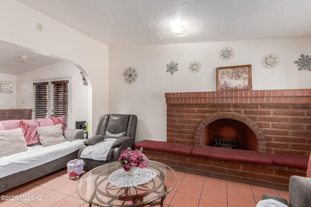 414 E 34th St, Tucson, AZ 85713 - living area featuring arched walkways, tile patterned flooring, a fireplace, and a textured ceiling