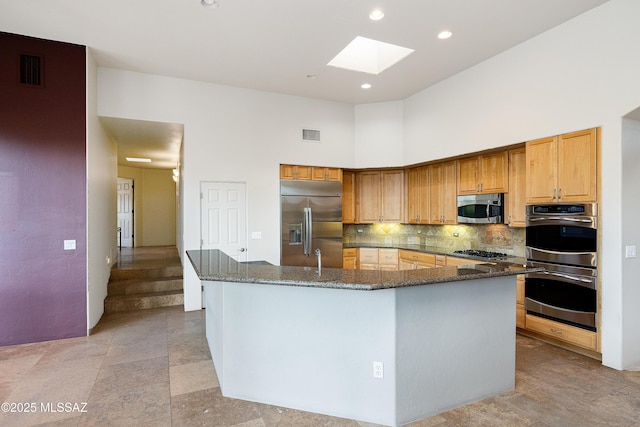 5327 N Ventana Overlook Pl, Tucson, AZ 85750 - kitchen featuring dark stone countertops, tasteful backsplash, a skylight, and stainless steel appliances