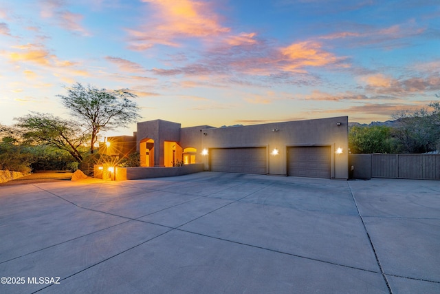 5327 N Ventana Overlook Pl, Tucson, AZ 85750 - pueblo-style house featuring a garage, fence, stucco siding, and driveway