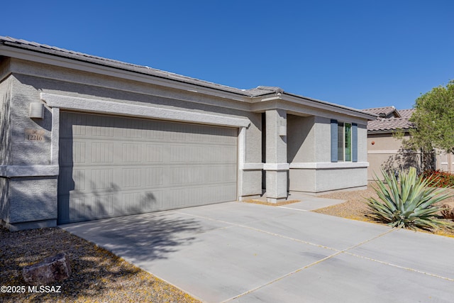 view of front of home featuring an attached garage, stucco siding, driveway, and a tile roof