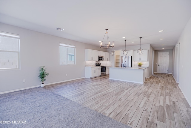 kitchen with stainless steel appliances, open floor plan, recessed lighting, tasteful backsplash, and visible vents