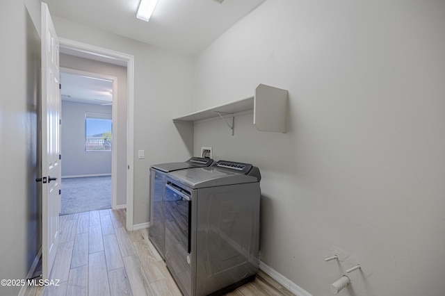 laundry area with light wood-style floors, baseboards, laundry area, and independent washer and dryer