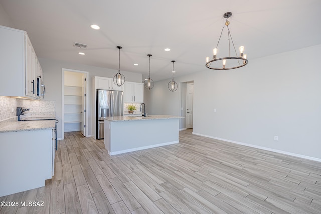 kitchen featuring recessed lighting, a sink, appliances with stainless steel finishes, and light wood-style flooring