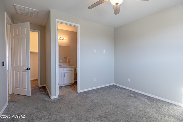 unfurnished bedroom with a ceiling fan, visible vents, carpet floors, baseboards, and ensuite bathroom