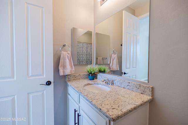 bathroom featuring vanity and a textured wall