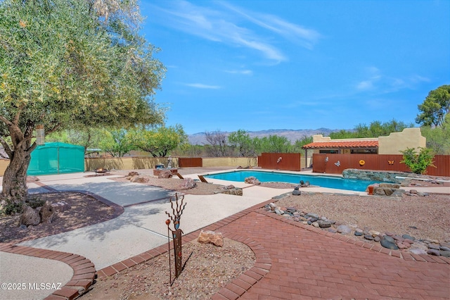 view of swimming pool featuring a patio, a fenced in pool, fence private yard, and a mountain view