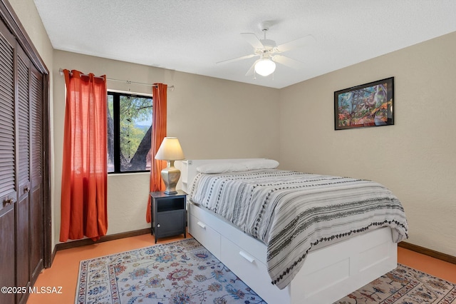 bedroom with baseboards, ceiling fan, a textured ceiling, and a closet