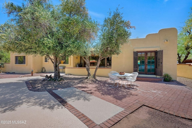 back of house featuring a patio, stucco siding, and french doors