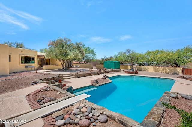 view of swimming pool featuring a fenced in pool, a patio area, a shed, an outbuilding, and a fenced backyard