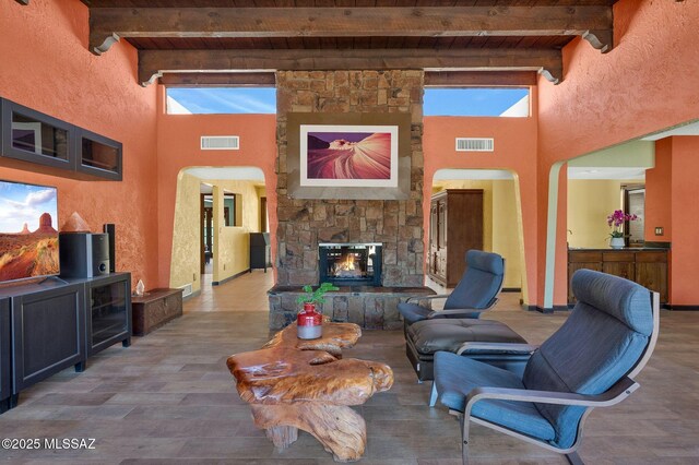 living room featuring beam ceiling, visible vents, and wood ceiling