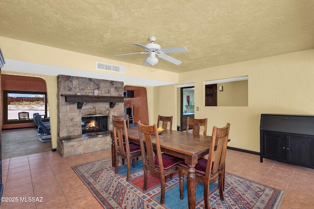 dining room featuring light tile patterned floors, visible vents, ceiling fan, and a textured ceiling