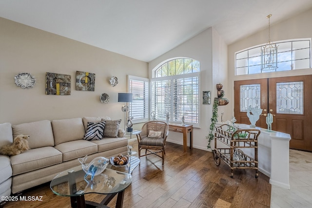 living room with baseboards, high vaulted ceiling, wood finished floors, and a notable chandelier