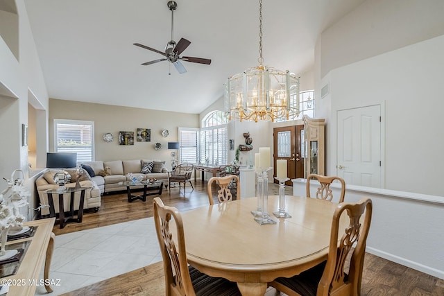 dining room with visible vents, ceiling fan with notable chandelier, a wealth of natural light, and high vaulted ceiling