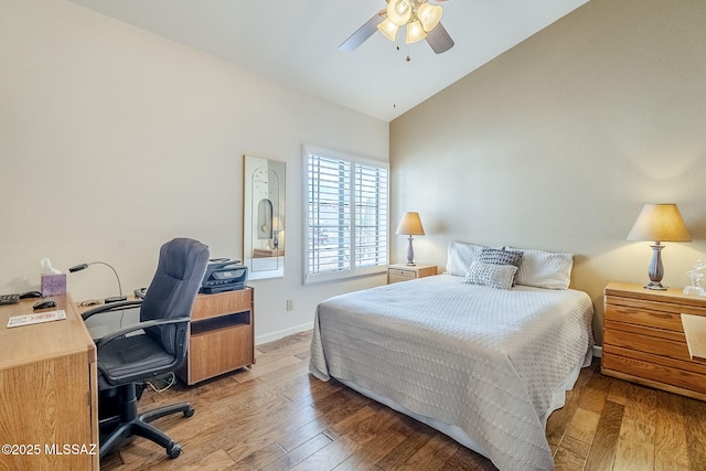 bedroom with baseboards, ceiling fan, wood finished floors, and high vaulted ceiling