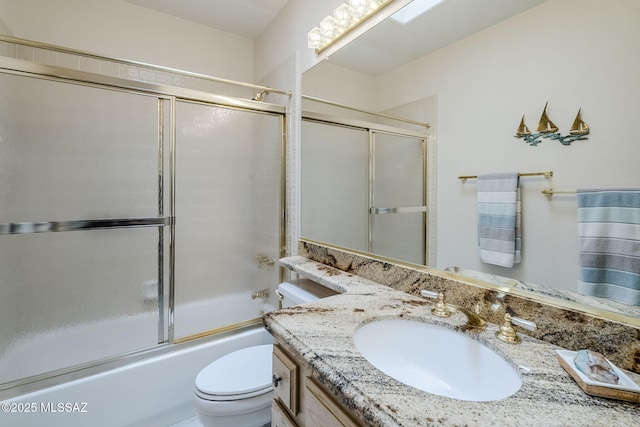bathroom featuring vanity, toilet, and shower / bath combination with glass door