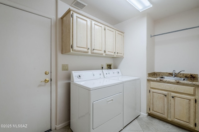 washroom featuring visible vents, separate washer and dryer, a sink, cabinet space, and light tile patterned floors