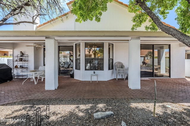 rear view of house with a ceiling fan, a patio area, and stucco siding