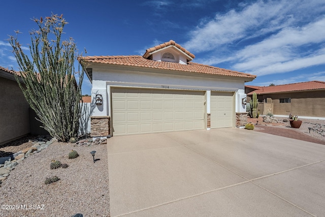 mediterranean / spanish house featuring stone siding, stucco siding, concrete driveway, an attached garage, and a tile roof