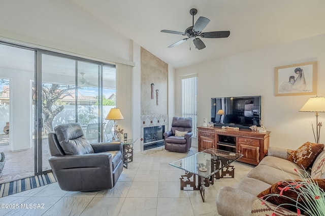 living room featuring a ceiling fan, high vaulted ceiling, a tiled fireplace, and a healthy amount of sunlight