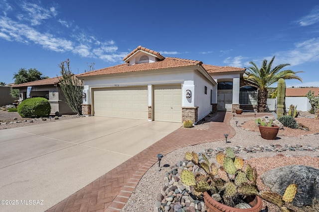 mediterranean / spanish home with stone siding, stucco siding, concrete driveway, an attached garage, and a tile roof