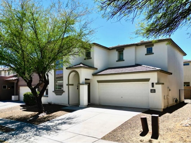 traditional-style home featuring a garage, stucco siding, concrete driveway, and a tile roof