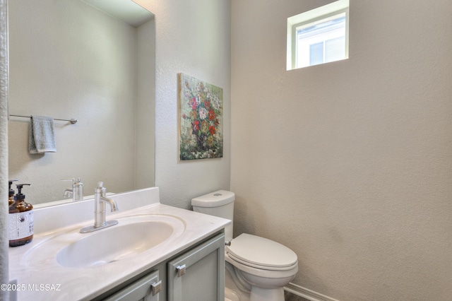half bath featuring vanity and toilet