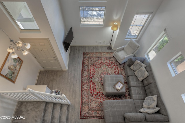 living room with baseboards, a high ceiling, and wood finished floors