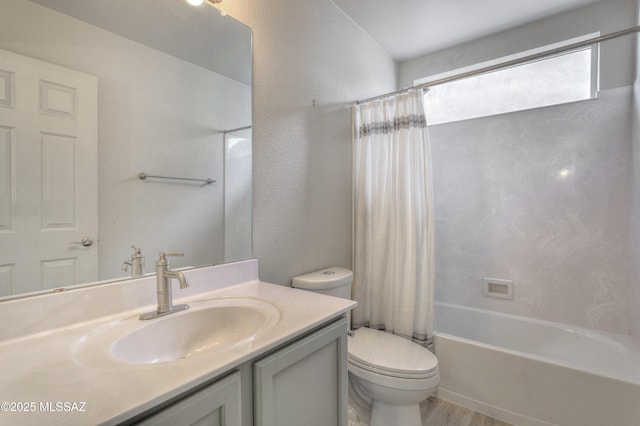 bathroom featuring vanity, shower / bath combo with shower curtain, a textured wall, wood finished floors, and toilet