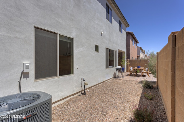 exterior space with a fenced backyard, a patio area, and central air condition unit