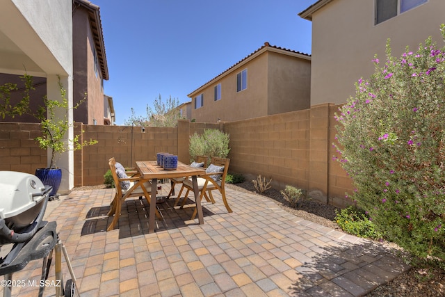 view of patio / terrace with grilling area, outdoor dining area, and a fenced backyard