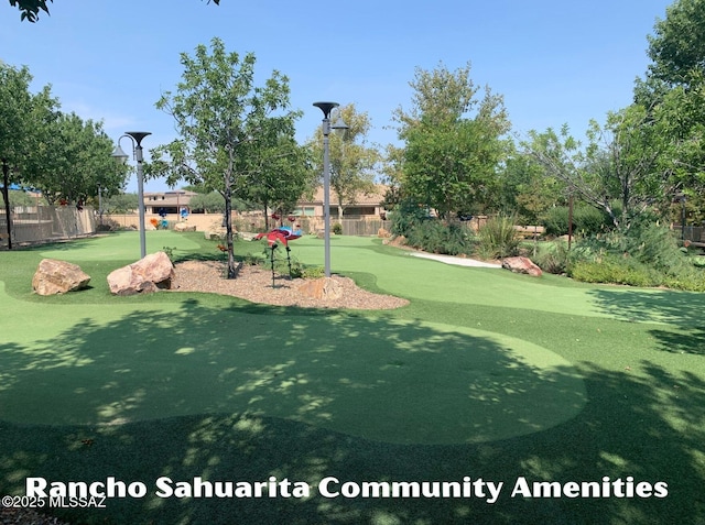 view of property's community featuring view of golf course and fence