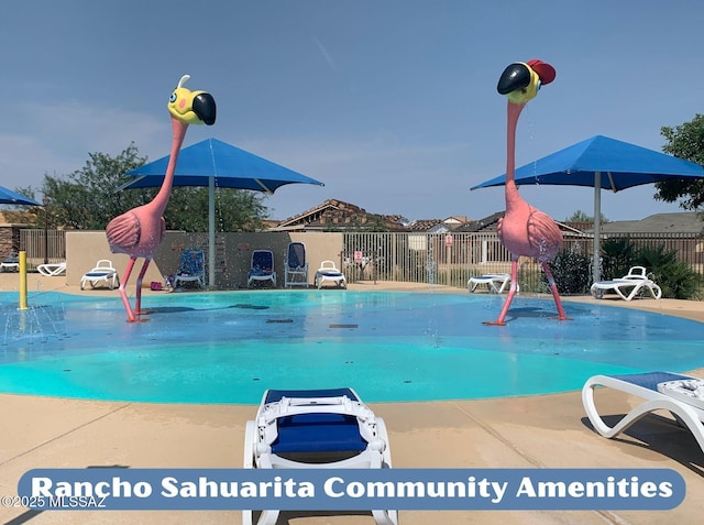 view of swimming pool featuring fence and a water play area