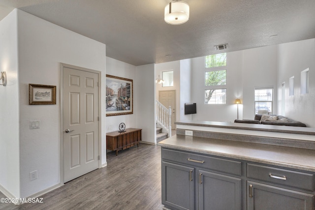 kitchen featuring visible vents, wood finished floors, baseboards, open floor plan, and gray cabinetry