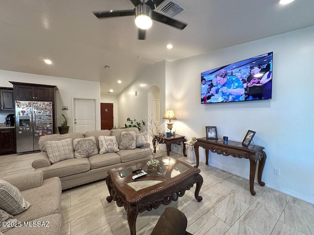 living room featuring arched walkways, baseboards, visible vents, lofted ceiling, and a ceiling fan